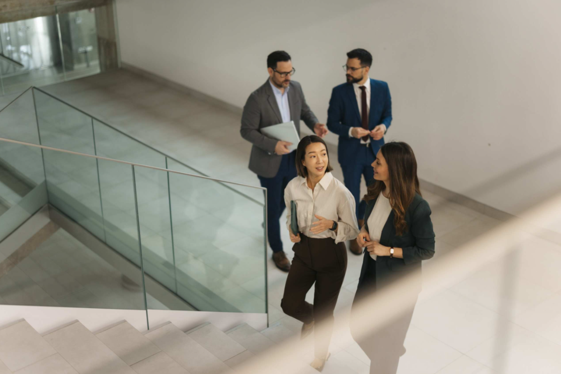 Four business people walking up stairs