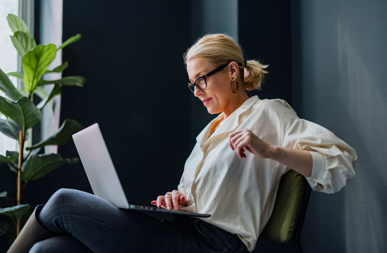 Woman sitting back working on laptop