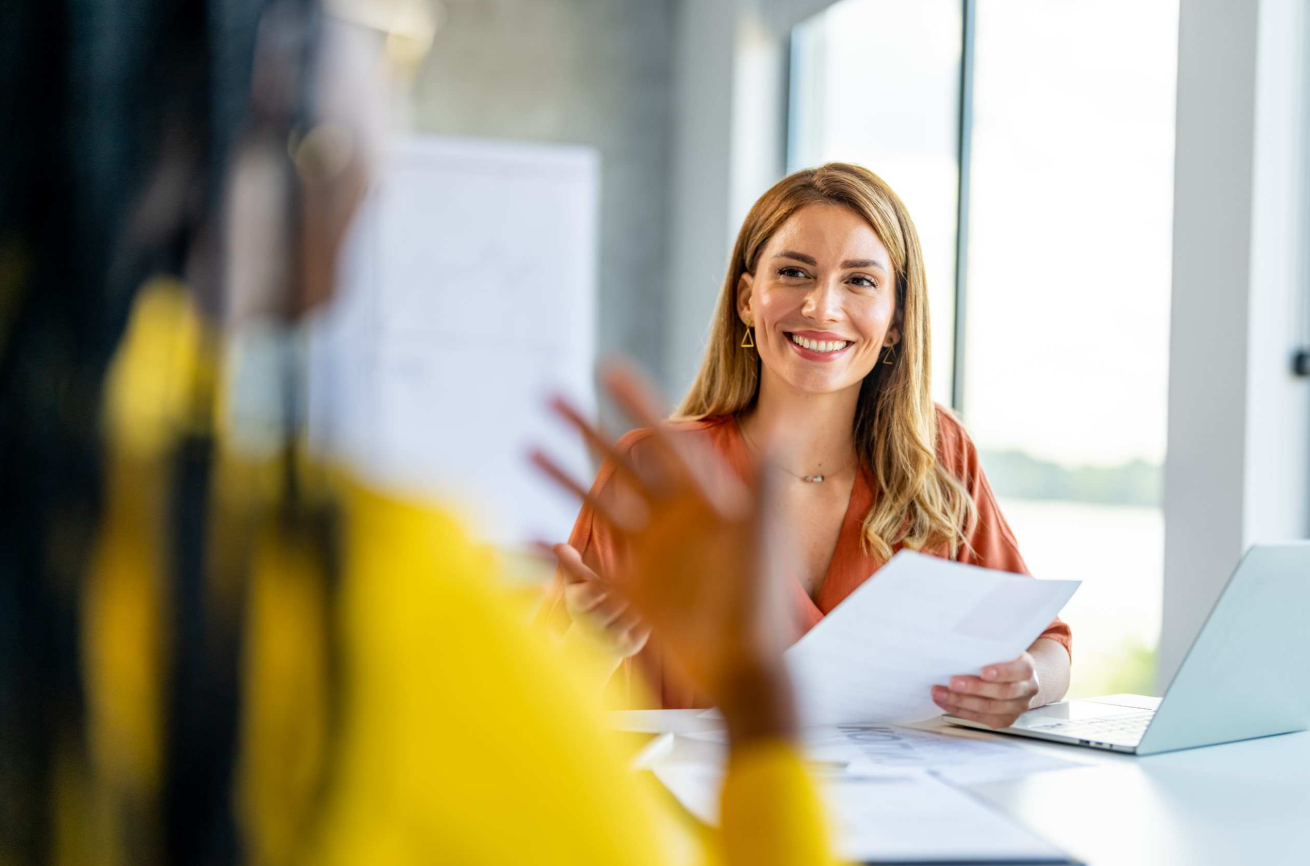 Two women talking in office at table